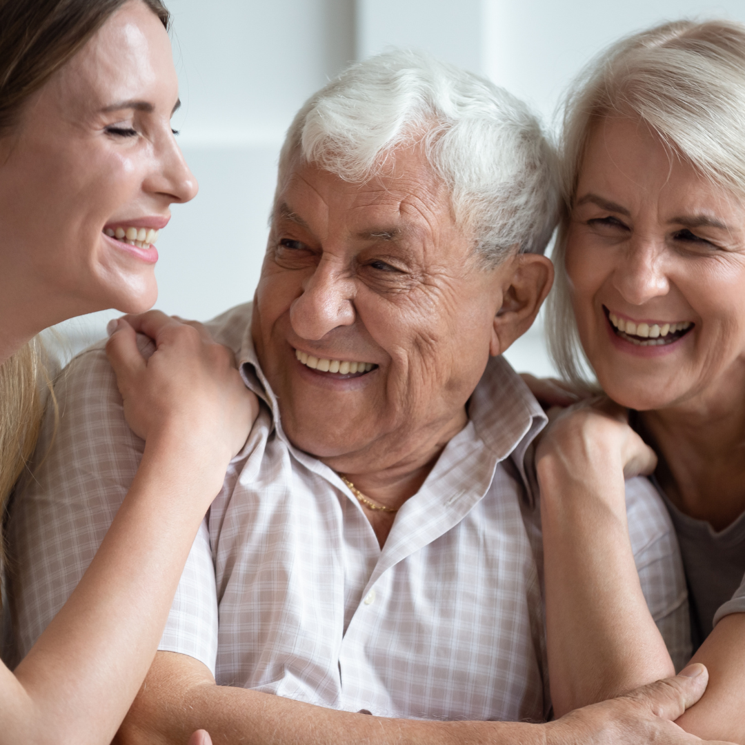Eltern mit ihrer erwachsenen Tochter, sorgenfrei durch eine private Pflegeversicherung.
