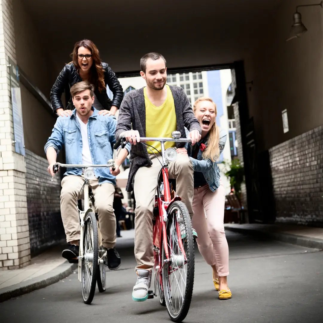 Junge Erwachsene fahren Fahrrad, sorgenfrei durch eine Unfallversicherung.