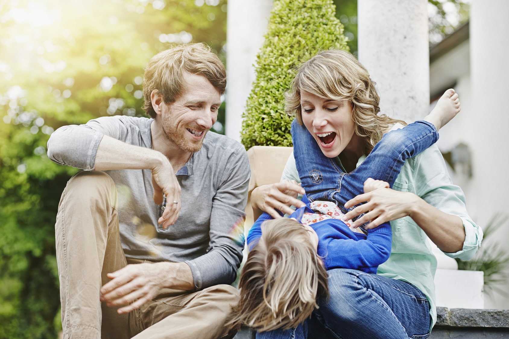 Junge Eltern mit ihrem Kind am spielen, nach der Absicherung der Familie.