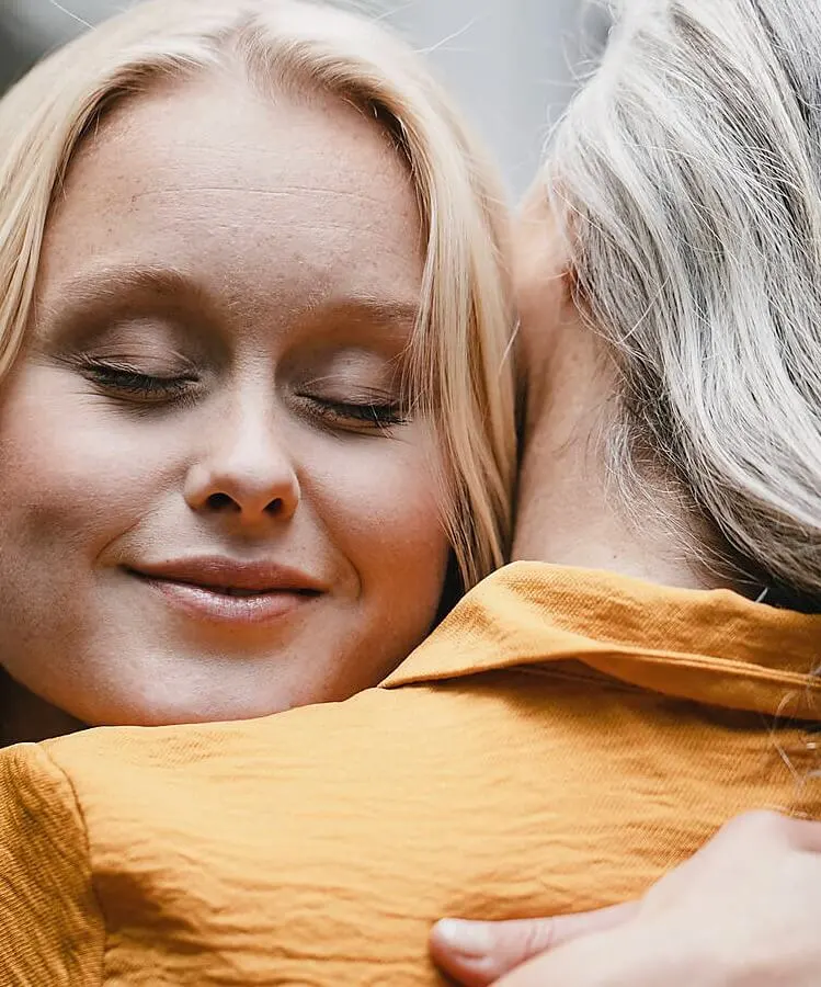 Eine Frau die eine ältere umarmt, sorgenfrei durch eine Sterbegeldversicherung.