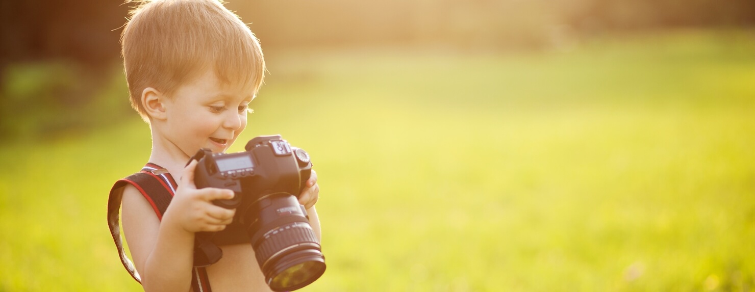 Kleiner junge mit Kamera und Haftplichtversicherung.