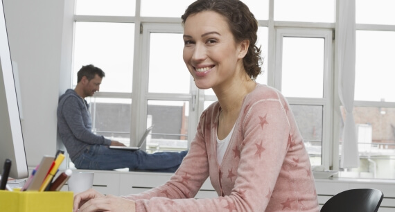 Frau an ihrem Arbeitsplatz, sorgenfrei durch den Berufsrechtsschutz.