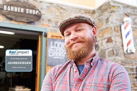 Mann ,der ideal Pflegetagegeld beansprucht, steht vor seinem Barber Shop. 